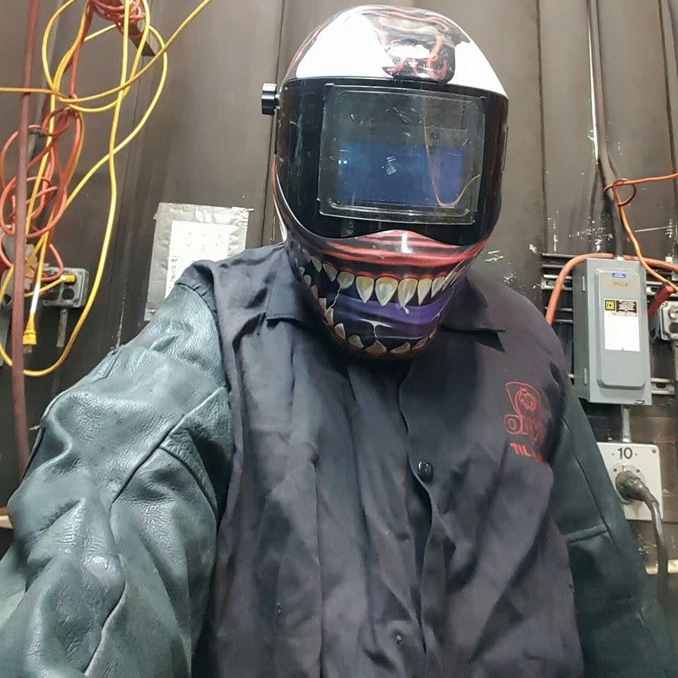 Old Dominion Welding LLC welder in shop wearing welding helmet and leather jacket
